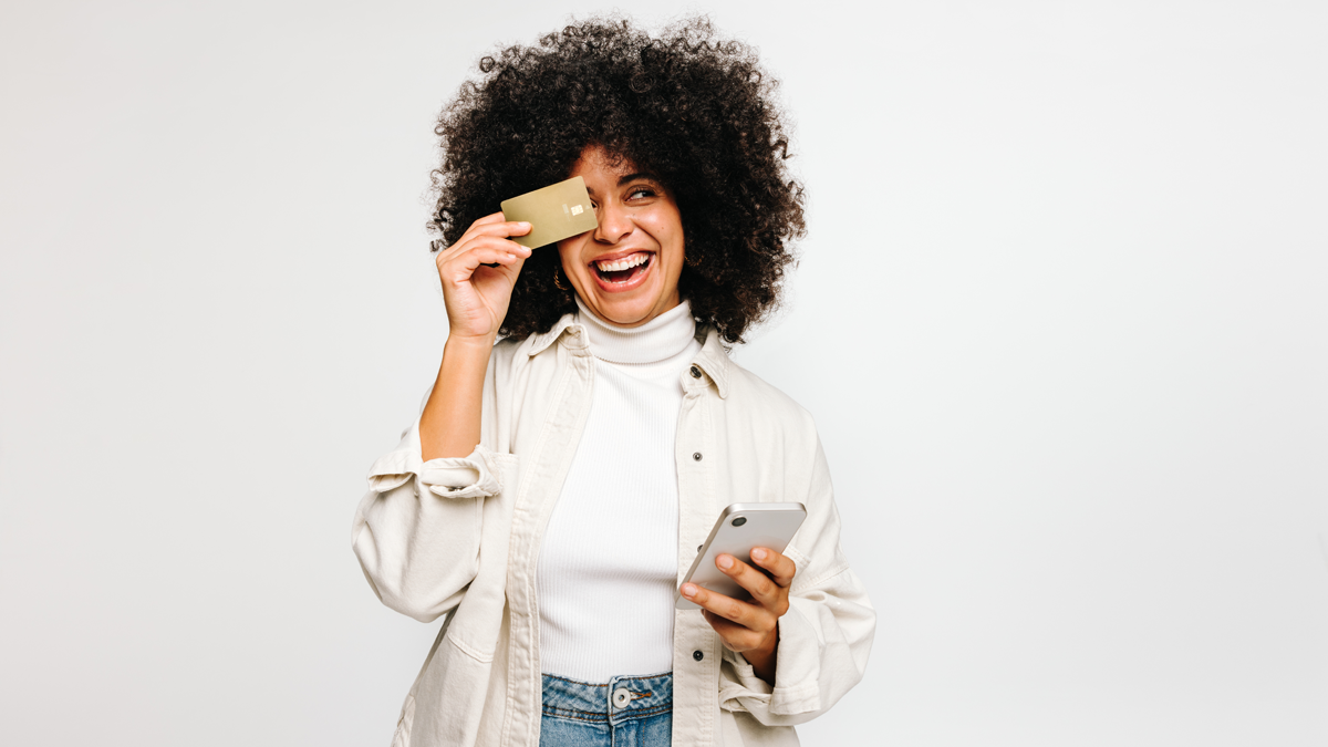 black woman smiling and holding a credit card