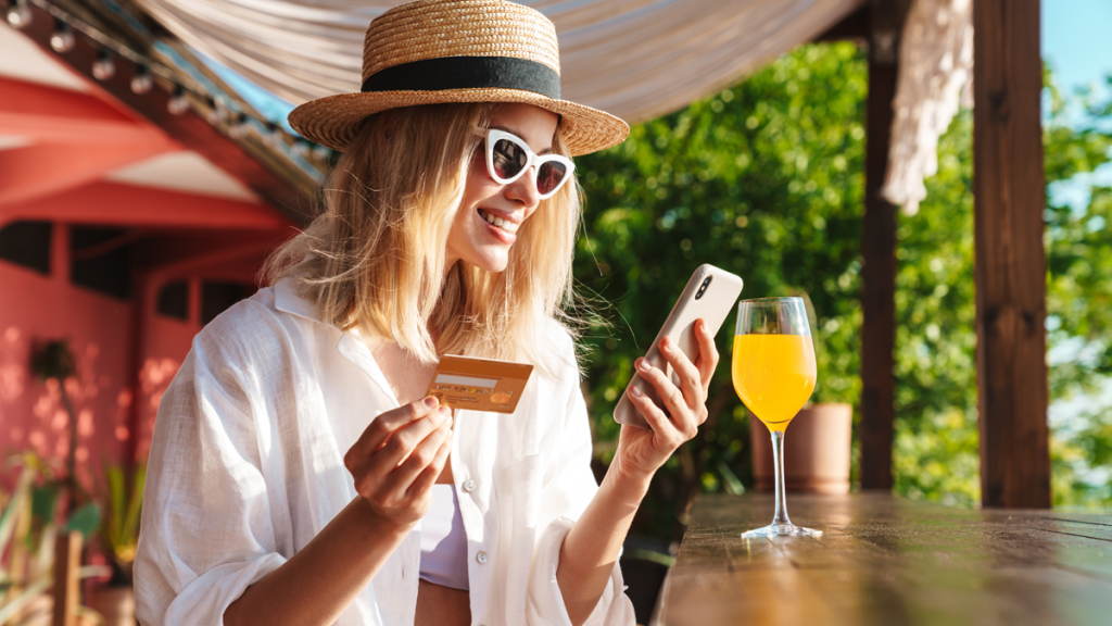 blonde woman on vacation, holding her phone and a credit card